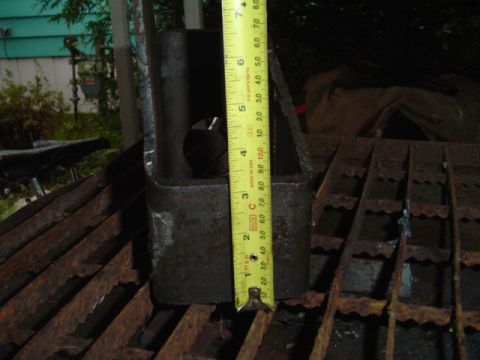 1993 Ford Bronco - Metal bracket with a tape measure for scale. The part appears to be rusty.