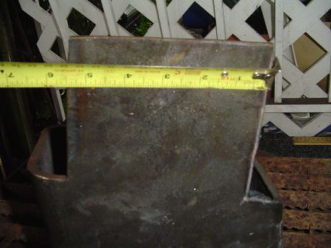 1993 Ford Bronco - A tape measure is used to measure a metal bracket, possibly a vehicle part.