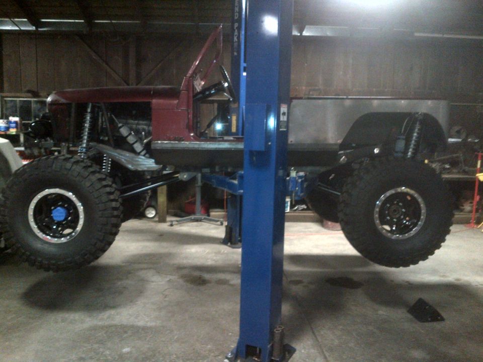 Customized off-road vehicle with large tires on a lift, side view