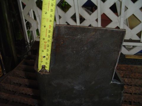 1993 Ford Bronco - A metal bracket is measured with a tape measure, indicating its size.