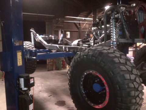 1985 Jeep CJ7 - This heavily modified off-road vehicle is on a lift, showing its frame and large tires.