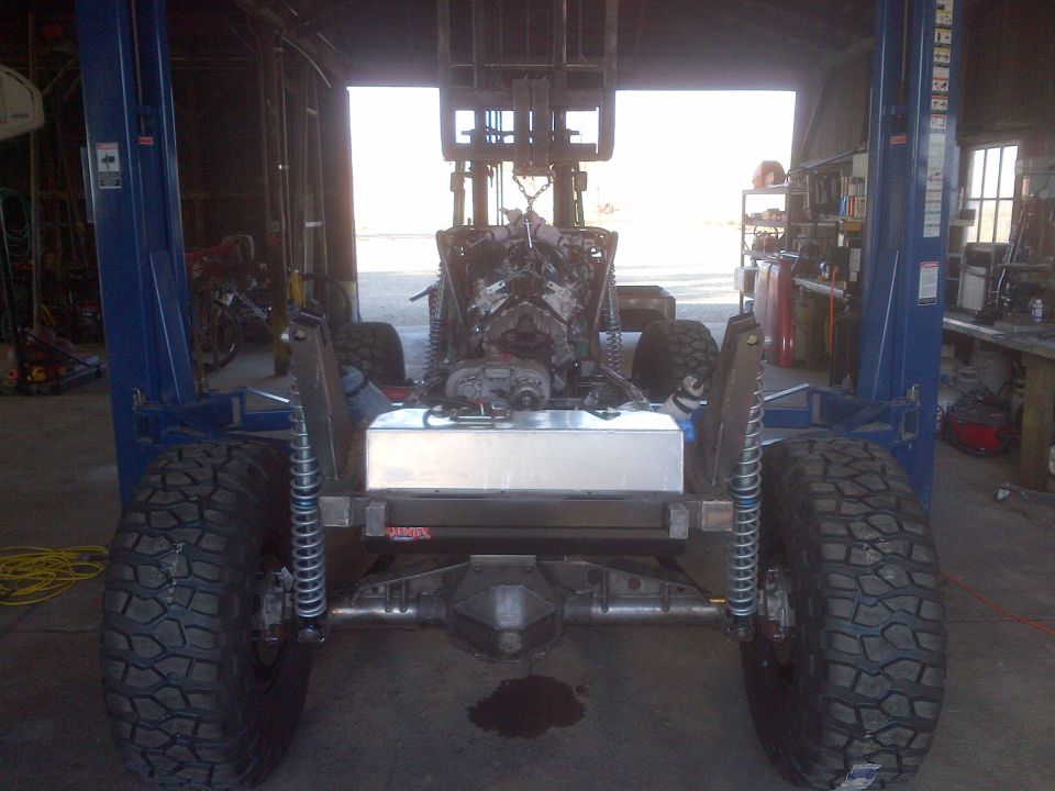 1985 Jeep CJ7 frame with engine and fuel tank visible, on a lift
