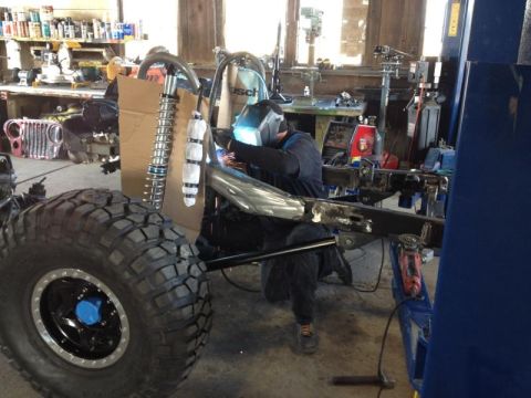 1985 Jeep CJ7 - Welding work on a 1985 Jeep CJ7 frame in a garage setting.