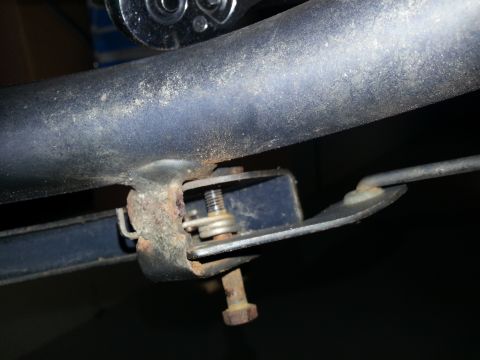1994 Ford Bronco - Detail of a rusty bracket and bolt assembly, likely from a vehicle's undercarriage.