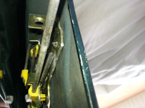 1994 Ford Bronco - The internal workings of a vehicle's door latch assembly are visible in this close-up shot.