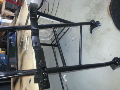 1994 Ford Bronco - These black painted metal components appear to be parts of a vehicle's frame or suspension system.