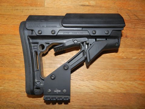 1996 Ford Bronco - A black adjustable gun stock is shown against a wooden background, with visible text and mounting hardware.