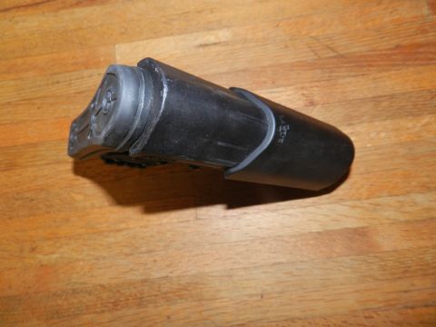 1996 Ford Bronco - A black plastic automotive part with a rubber end is shown against a wooden background. Text is visible on the part.
