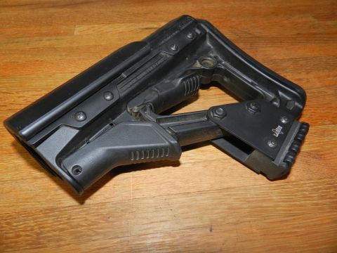 1996 Ford Bronco - This is a close-up of a black, adjustable gun stock resting on a wooden surface.