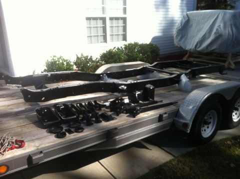 1979 Ford Bronco - Frame and suspension parts are organized on a trailer, ready for restoration or transport.