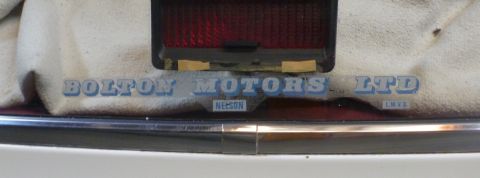 1969 Lincoln Continental - Detail of a vehicle's rear end, showing taillight and bumper trim with dealer text.