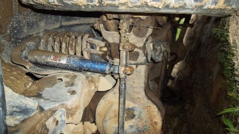1990 Ford Bronco - Close-up of a vehicle's suspension system, showing a shock absorber and coil spring.