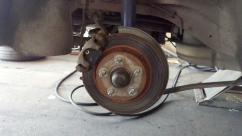 1996 Ford Taurus - The photo shows a close-up view of a vehicle's rear brake rotor and caliper, with visible rust on the components.