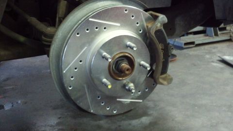 1996 Ford Taurus - Close-up of a drilled and slotted brake rotor and caliper, likely a replacement part.