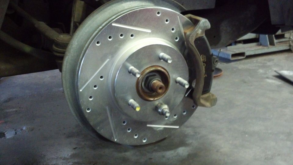 Drilled and slotted brake rotor and caliper