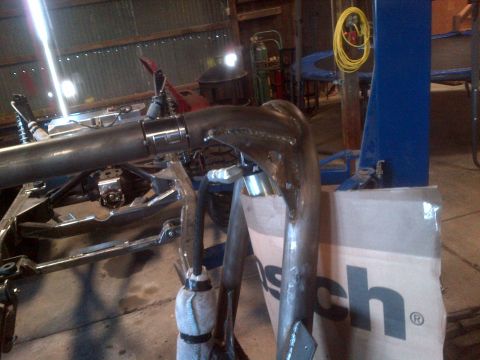 1985 Jeep CJ7 - Custom exhaust pipe and chassis components are visible in a workshop setting.