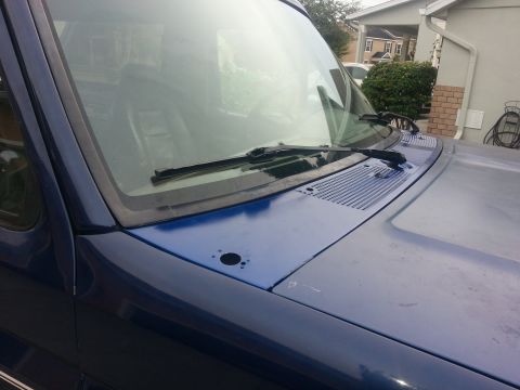 1994 Ford Bronco - The front of a blue SUV is shown, focusing on the hood and windshield area.