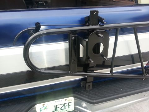 1994 Ford Bronco - Close-up of a spare tire carrier attached to the rear of a blue vehicle.