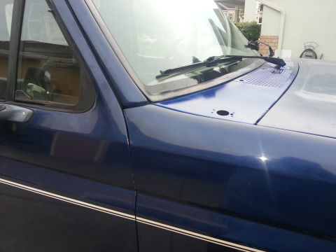 1994 Ford Bronco - Side view of a blue 1994 Ford Bronco, showing the fender and door with pinstripes.