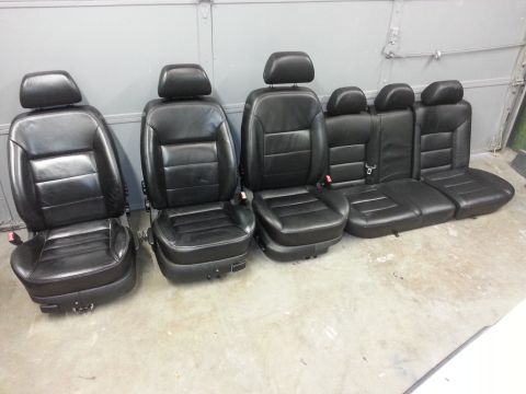 2002 Volkswagen Jetta - A set of black leather car seats, including front bucket seats and rear bench seats, are displayed indoors.