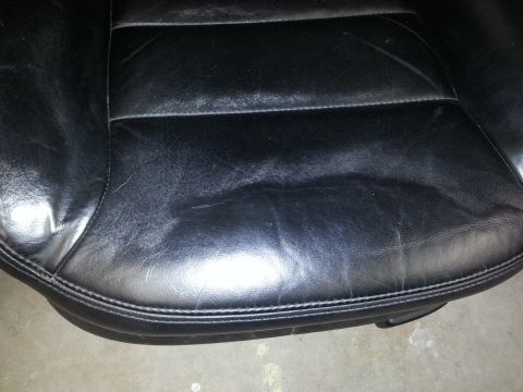 2002 Volkswagen Jetta - Worn black leather car seat shows signs of age and use.
