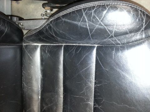 2002 Volkswagen Jetta - The interior of a vehicle shows aged black leather seats with visible cracks and wear.