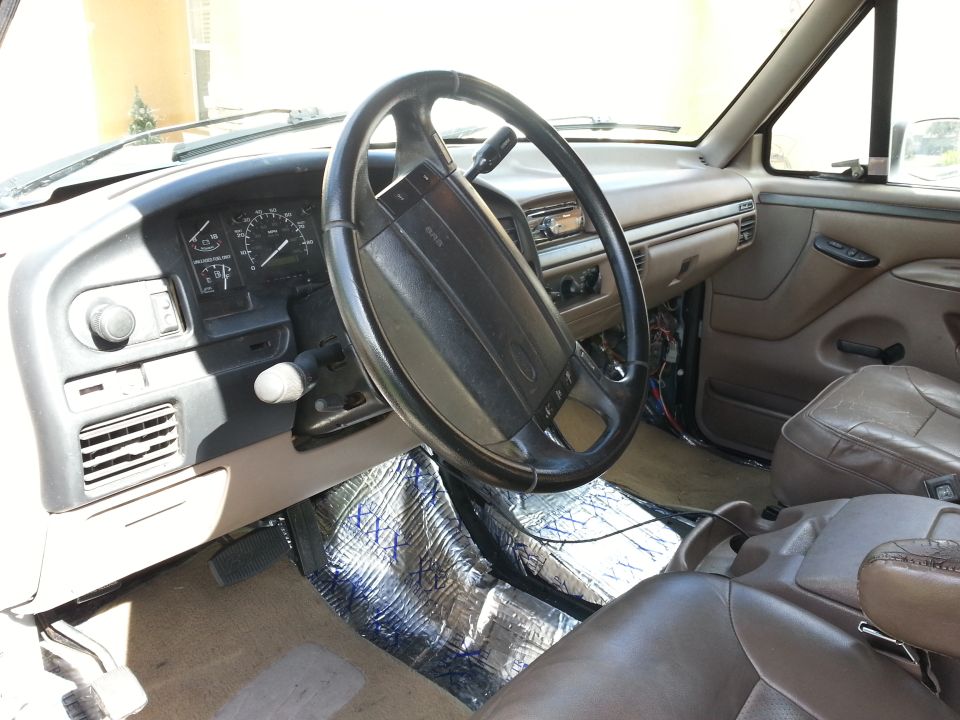 Brown leather seats and dashboard of a 1992 Ford Bronco interior with sound deadening on the floor