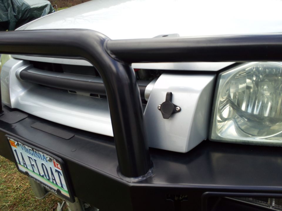 Front of a silver truck with a black bull bar and aftermarket bumper. Has a Virginia license plate that says '1A FLOAT'