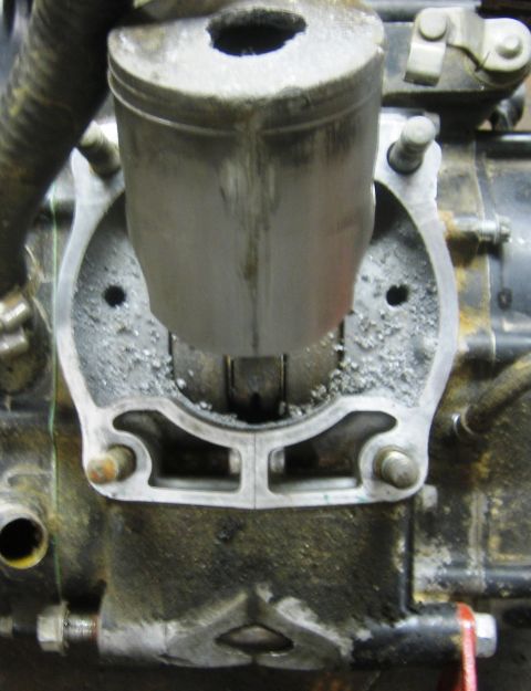 1900 Honda Big Red - This image shows a close-up view of an engine's cylinder and piston, with visible wear and debris.