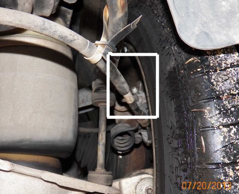 1998 Lincoln Mark VIII - Close-up view of a vehicle's suspension system, showing brake lines and springs.