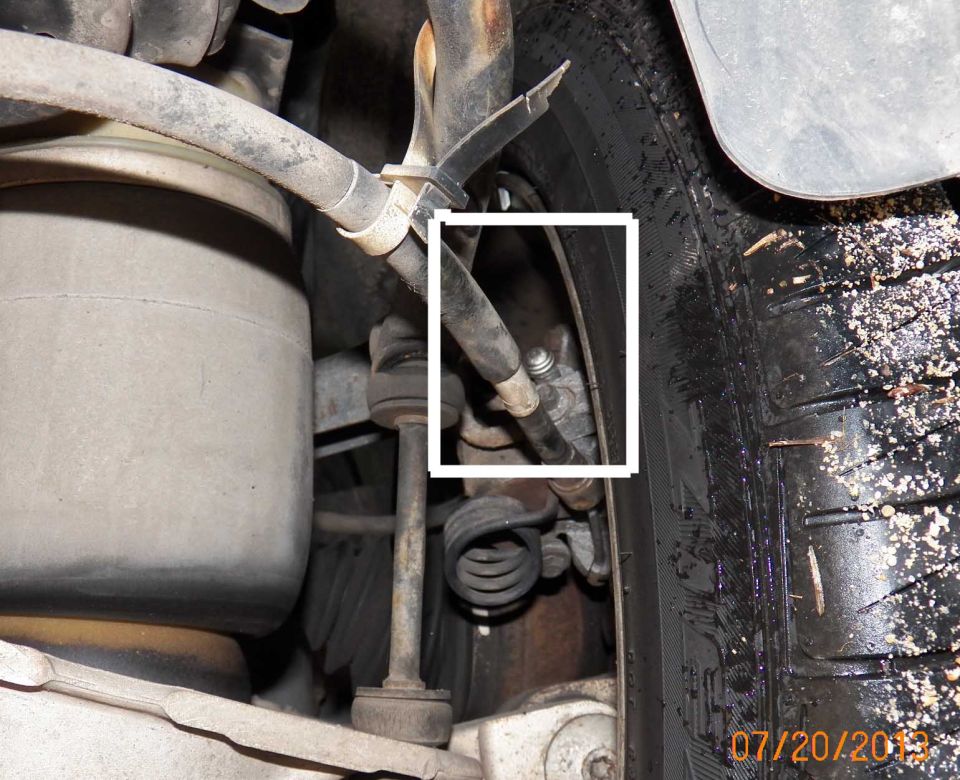 Car suspension with brake line, air spring, and coil spring visible