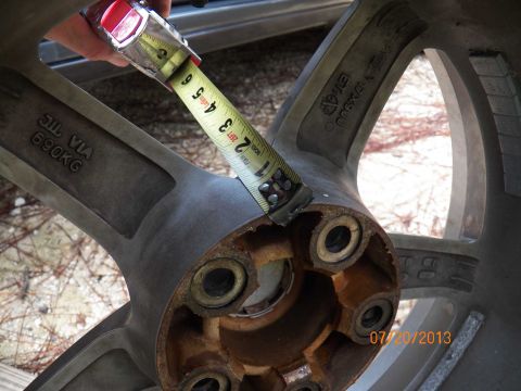 1998 Lincoln Mark VIII - A measuring tape is used to check the dimensions of a vehicle wheel, revealing various markings.