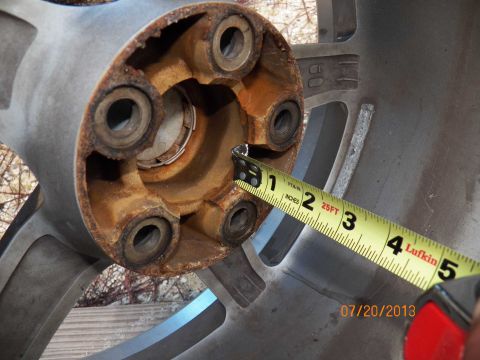 1998 Lincoln Mark VIII - A measuring tape is used to assess the condition of a rusty wheel hub, indicating a part rather than a full vehicle.