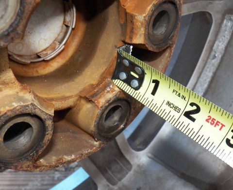 1998 Lincoln Mark VIII - A measuring tape is used to assess a rusty wheel hub, indicating a part measurement rather than a full vehicle identification.