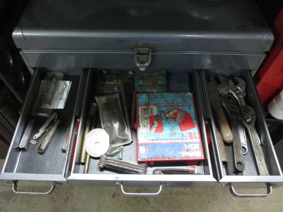 Open toolbox drawers filled with various tools like wrenches, screwdrivers, and Allen keys