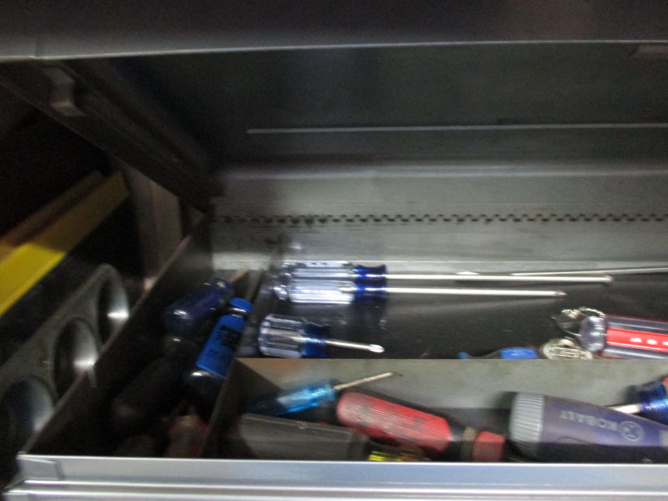 Tool chest with various screwdrivers, some with blue handles and others with red and purple handles