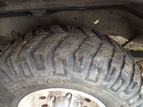 2000 Jeep Wrangler - Detail shot of a tire and suspension components on a vehicle.