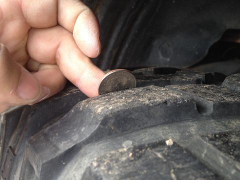 2000 Jeep Wrangler - Checking tire tread depth with a quarter.