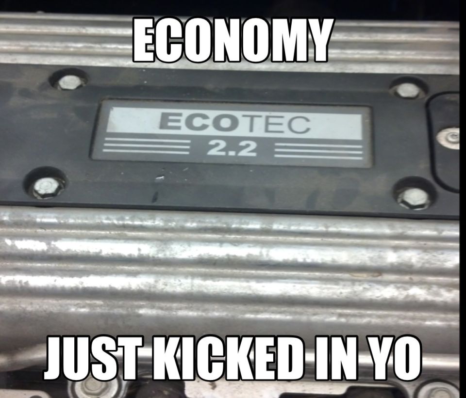Close-up of an engine cover with an Ecotec 2.2 badge. Text overlay says 'ECONOMY JUST KICKED IN YO'