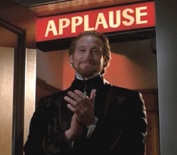 2000 Mercury Grand Marquis - A man in formal wear applauds under a lit APPLAUSE sign.