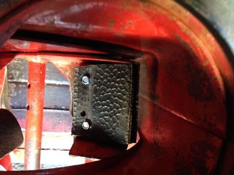 1999 Tomos Targa - Close-up view of a black textured part with rivets, mounted within a red housing.