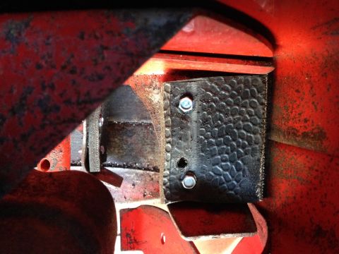 1999 Tomos Targa - Detail of a bolted component on a red piece of machinery.