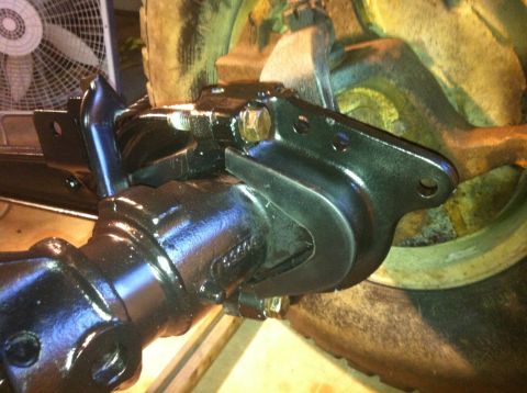 1979 Ford Bronco - Detail of a vehicle's rear axle assembly, focusing on the brake caliper bracket.