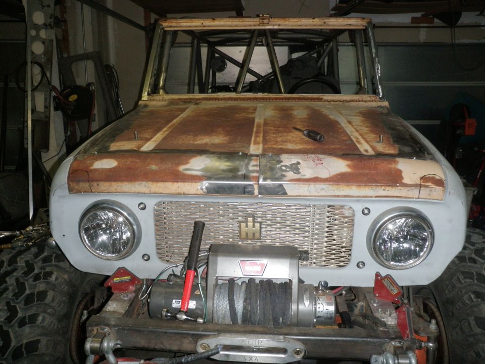 1961 International Scout 800 front end, showing rusted hood, grille with International logo, and a winch mounted below