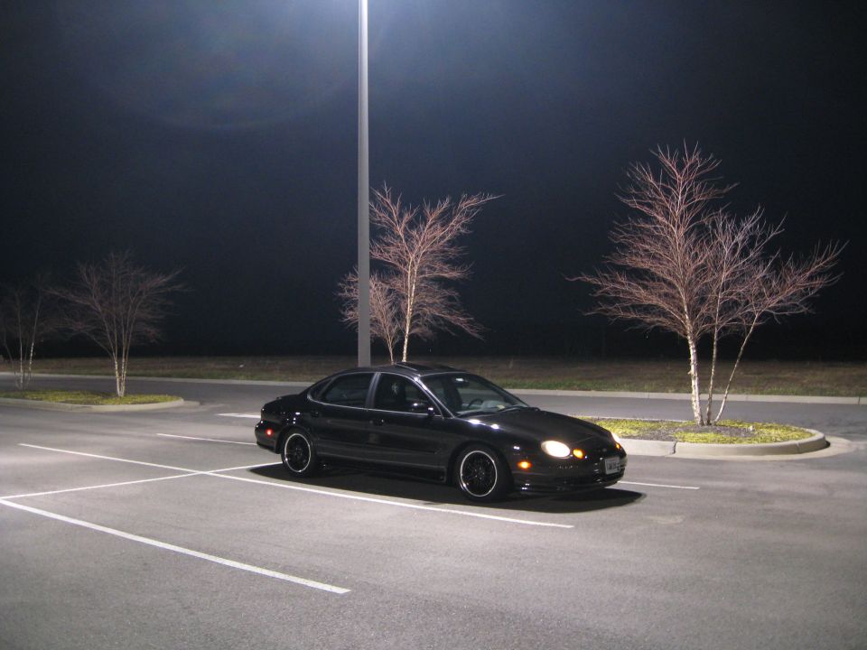 Black 1997 Ford Taurus parked at night