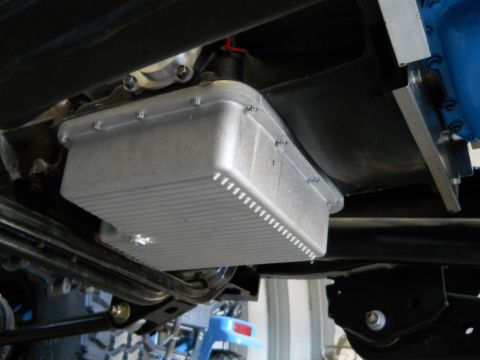 1992 Ford Bronco - Underside view of a vehicle's transmission oil pan, showing its ribbed design and bolted construction.