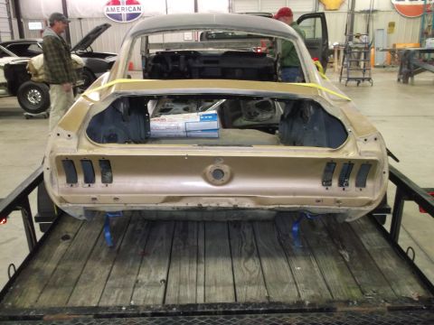 1967 Ford Mustang - Gold 1967 Ford Mustang rear end being transported on a trailer, undergoing restoration.