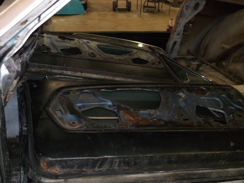 1967 Ford Mustang - The interior door panels of a 1967 Ford Mustang show significant rust and damage, indicating a need for restoration.