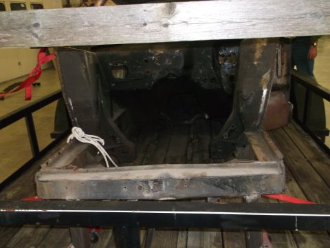 1967 Ford Mustang - The front section of a car's frame is loaded onto a trailer for transport.