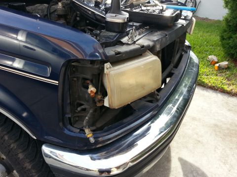 1994 Ford Bronco - Front view of a blue Ford truck with its headlight assembly removed for repair.